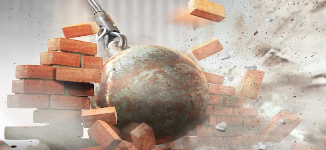 Wrecking ball hitting an demolishing brick wall